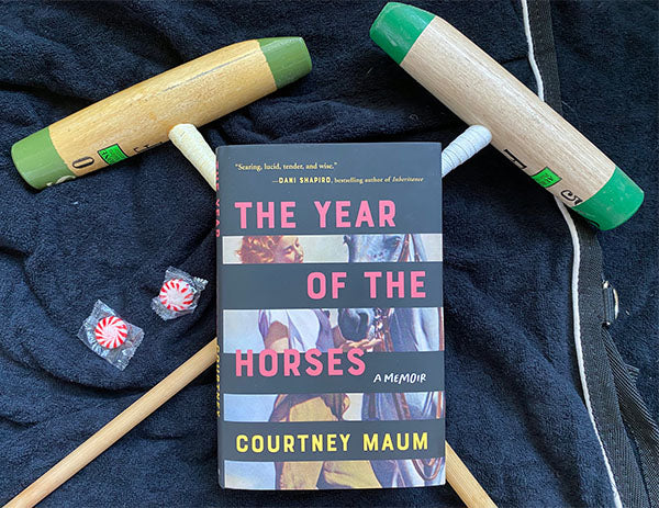 two polo mallets crossed with equestrian memoir The Year of the Horses by courtney Maum resting on top, horse books, equestrian memoir